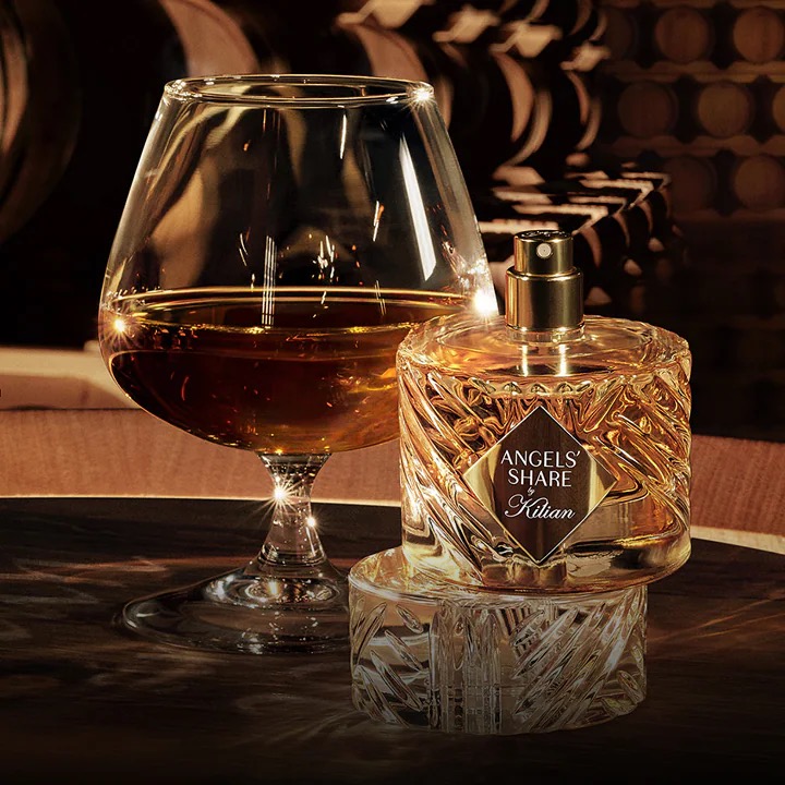 Flacon Angels' Share by Kilian et verre de cognac dans un chai
