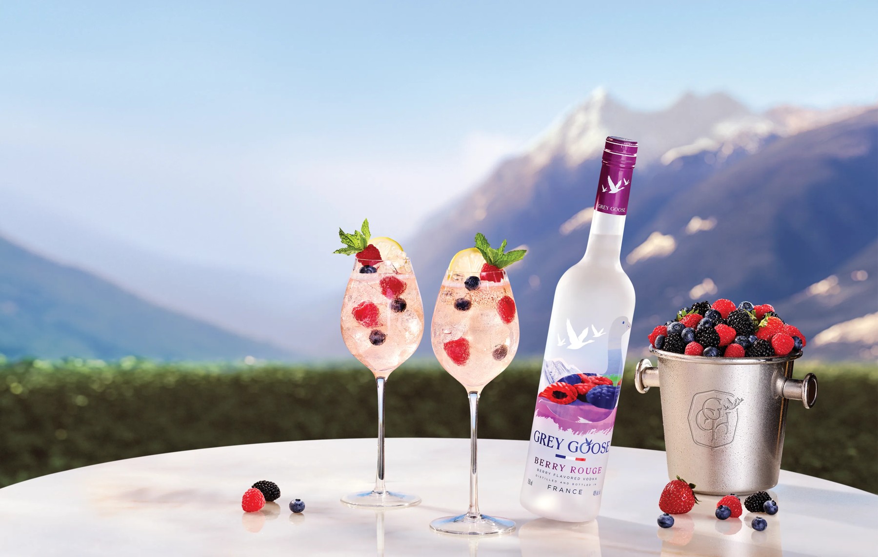 Bouteille Grey Goose Berry Rouge et cocktails aux baies dans le visuel officiel de la marque