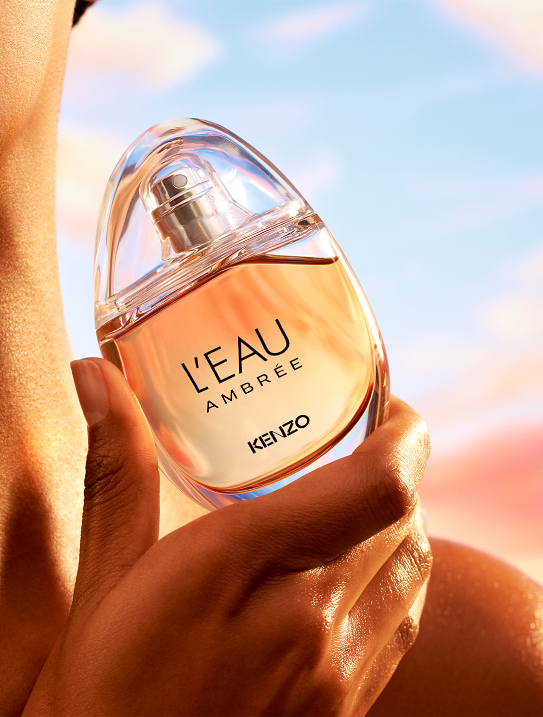 L’Eau Ambrée de Kenzo, flacon en forme de goutte dans la lumière solaire
