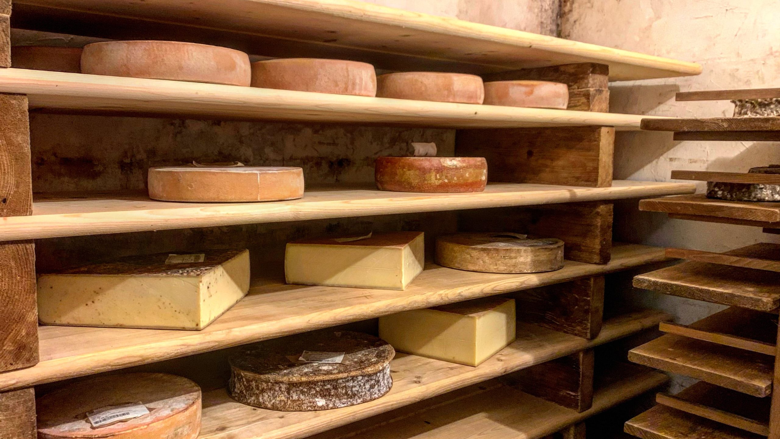 Meules de fromages fermiers dans la cave d'affinage de La Fromagerie à Méribel
