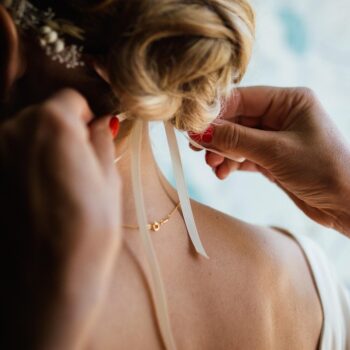 Collier et bijoux dorés portés avec une tenue de mariage